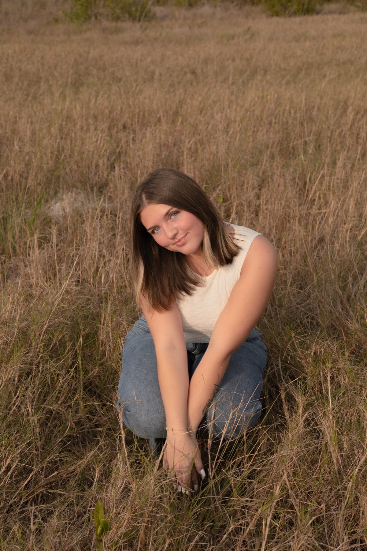 Crouched in tall golden grass, contemplative