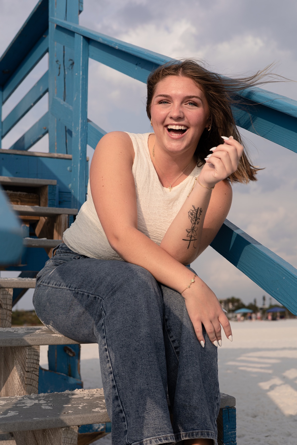 Wide laugh, hair caught in the beach breeze