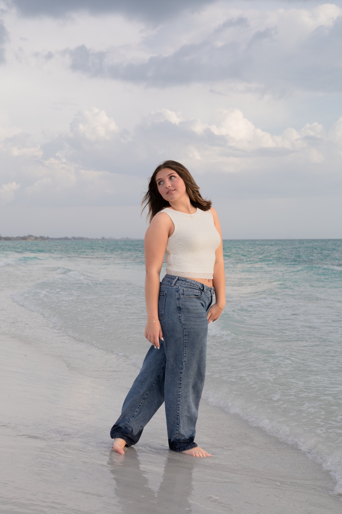 Barefoot at the turquoise shoreline, looking back