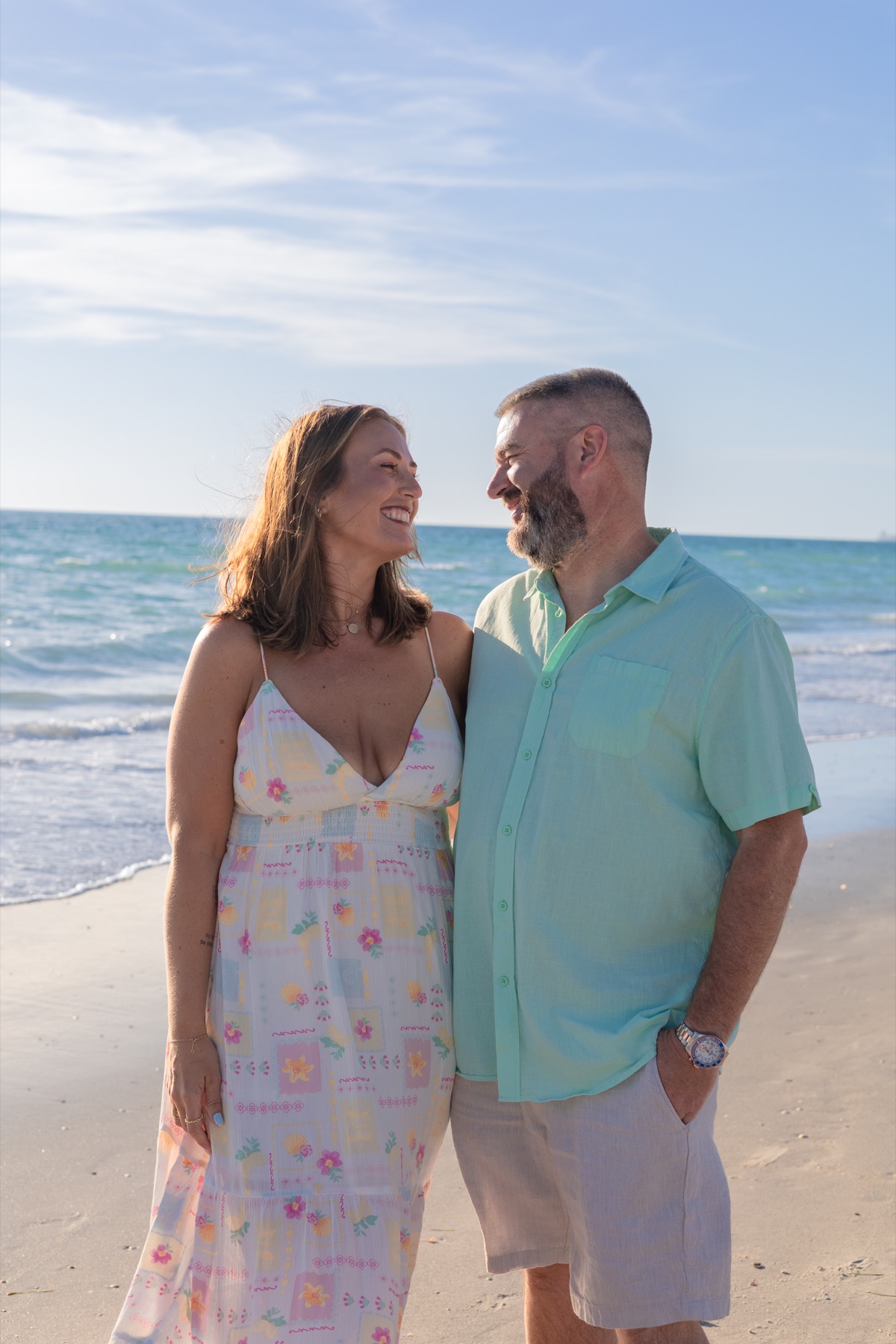 Couple smiling into each other on a warm beach