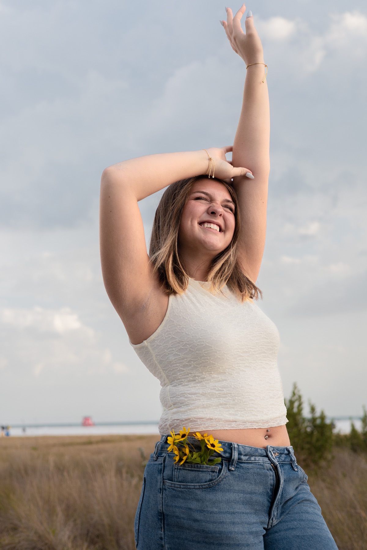 Sunflowers tucked at her waist, laughing in the field