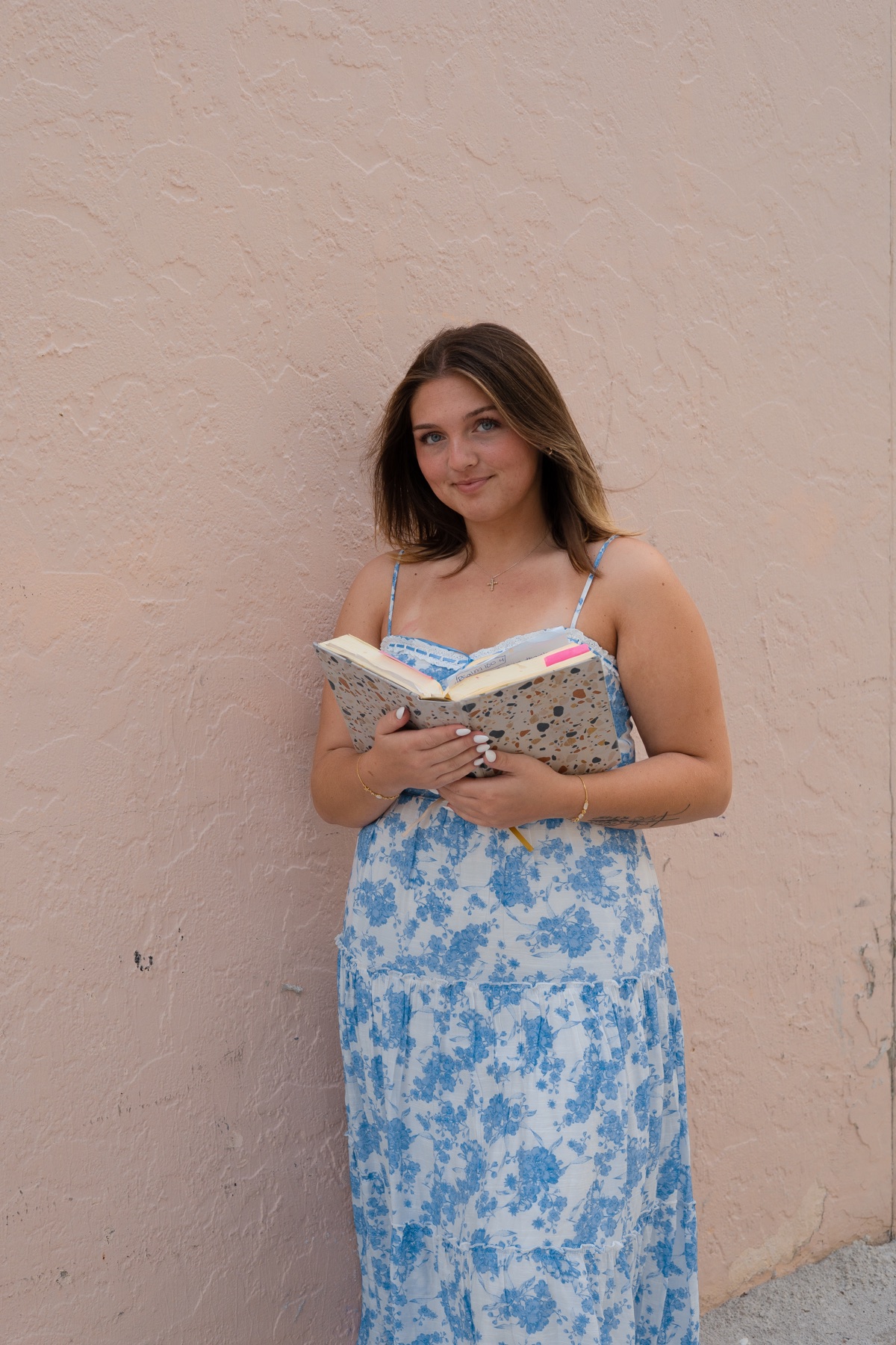 Quiet moment with an open book against blush stucco