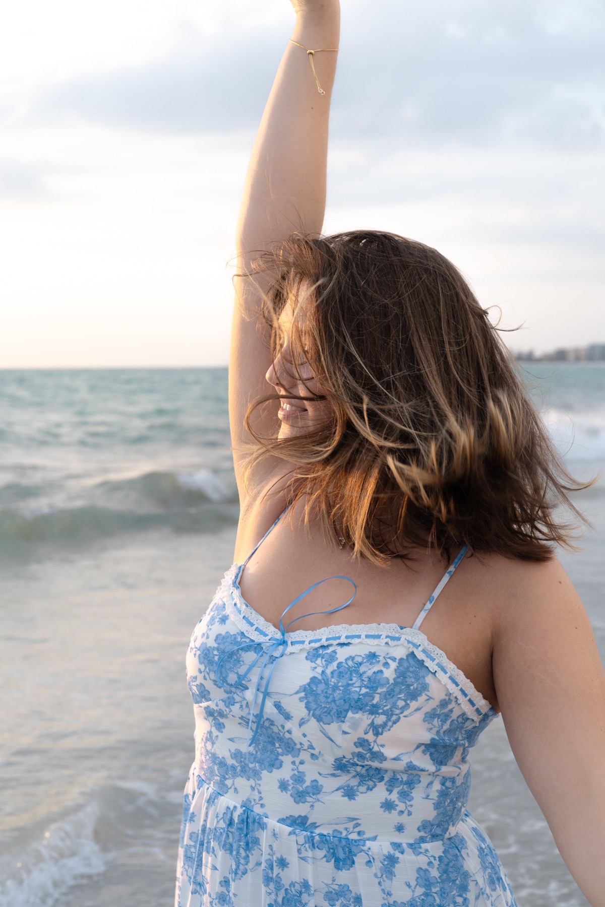Wind-swept ocean portrait, arm raised to the sky