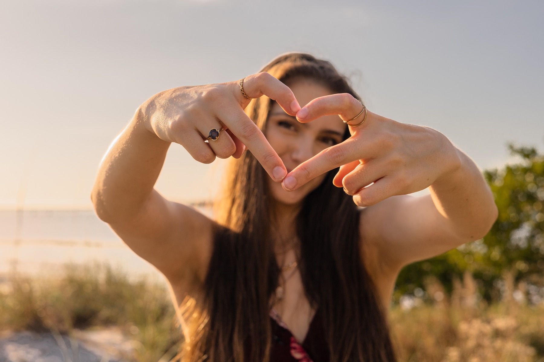 Hands forming a heart in front of the sun